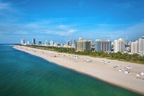 A coastal cityscape with a wide sandy beach, numerous high-rise buildings, and clear blue skies. - Royal Palm South Beach Miami, a Tribute Portfolio Resort (Miami Beach)