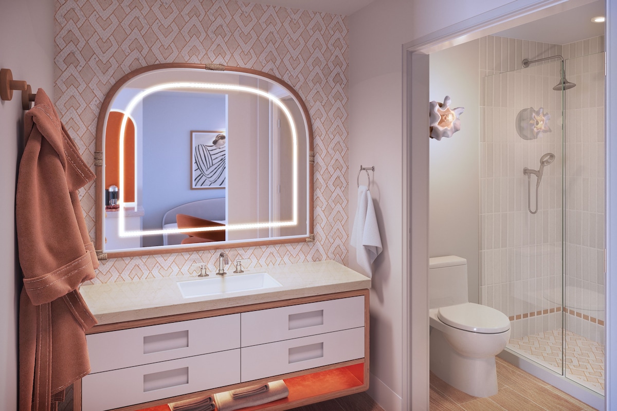 A bathroom with a vanity, a mirror, a towel rack, a toilet, and a shower enclosure.
