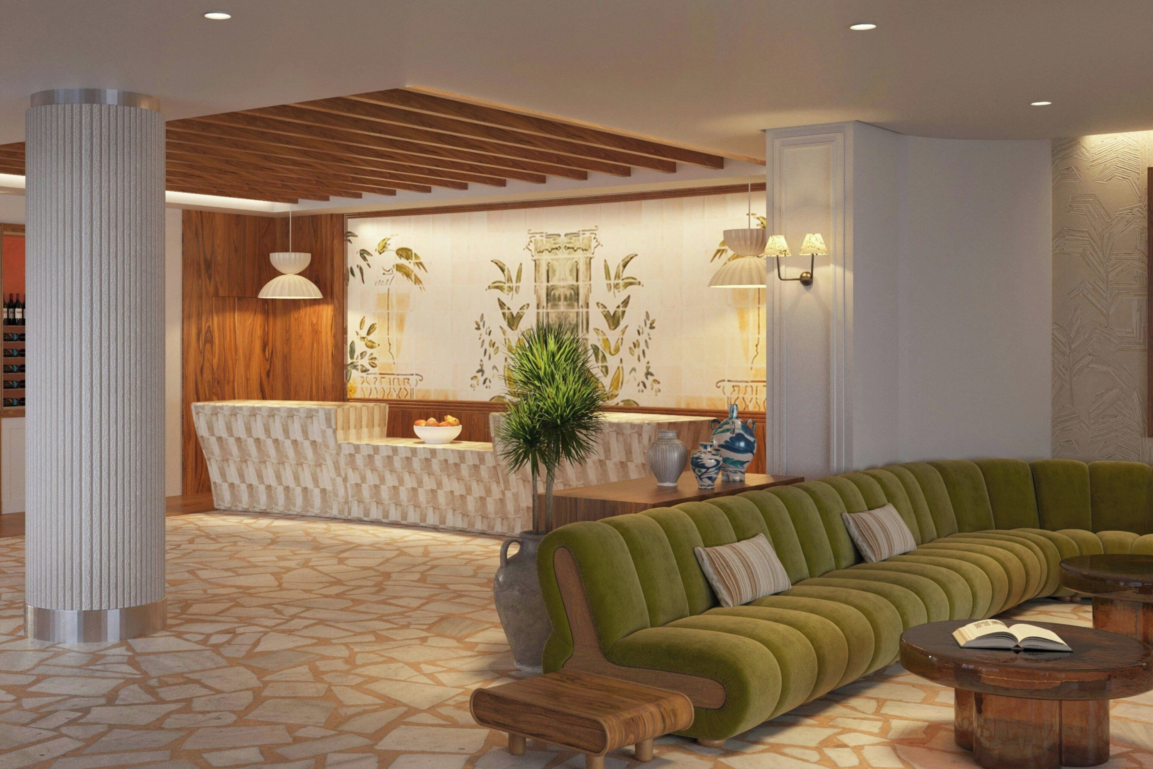 A modern lobby with a green sofa, wooden bench, and a reception desk.