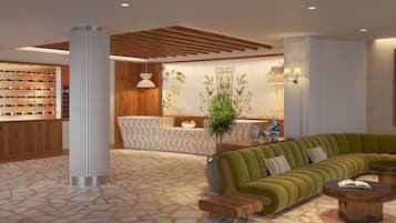A modern lobby with a green sofa, wooden reception desk, and a wine rack.