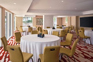 A conference room with multiple round tables, yellow chairs, and a red and white patterned carpet. - Royal Palm South Beach Miami, a Tribute Portfolio Resort (Miami Beach)