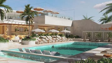 Una piscina al aire libre, sombrillas, sillones reclinables de piscina