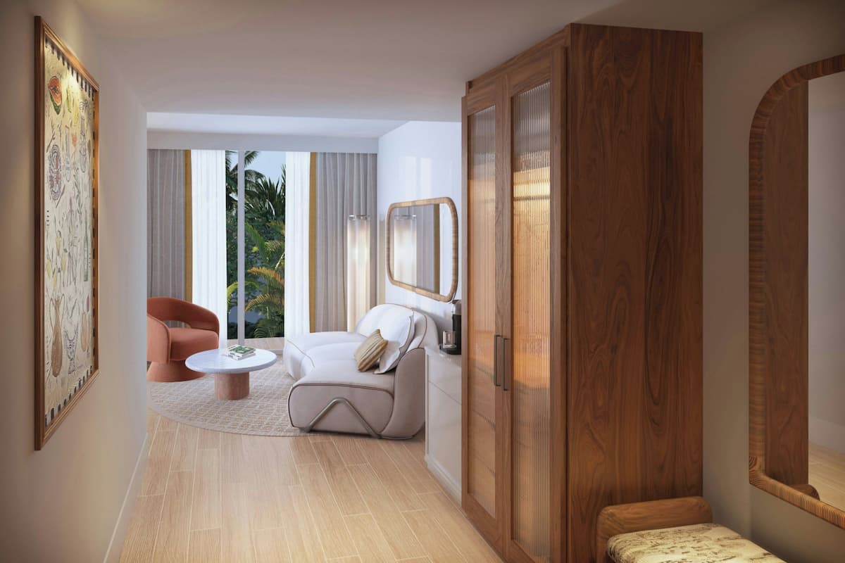 A modern room with a sofa, a small table, a cabinet, and a large mirror.