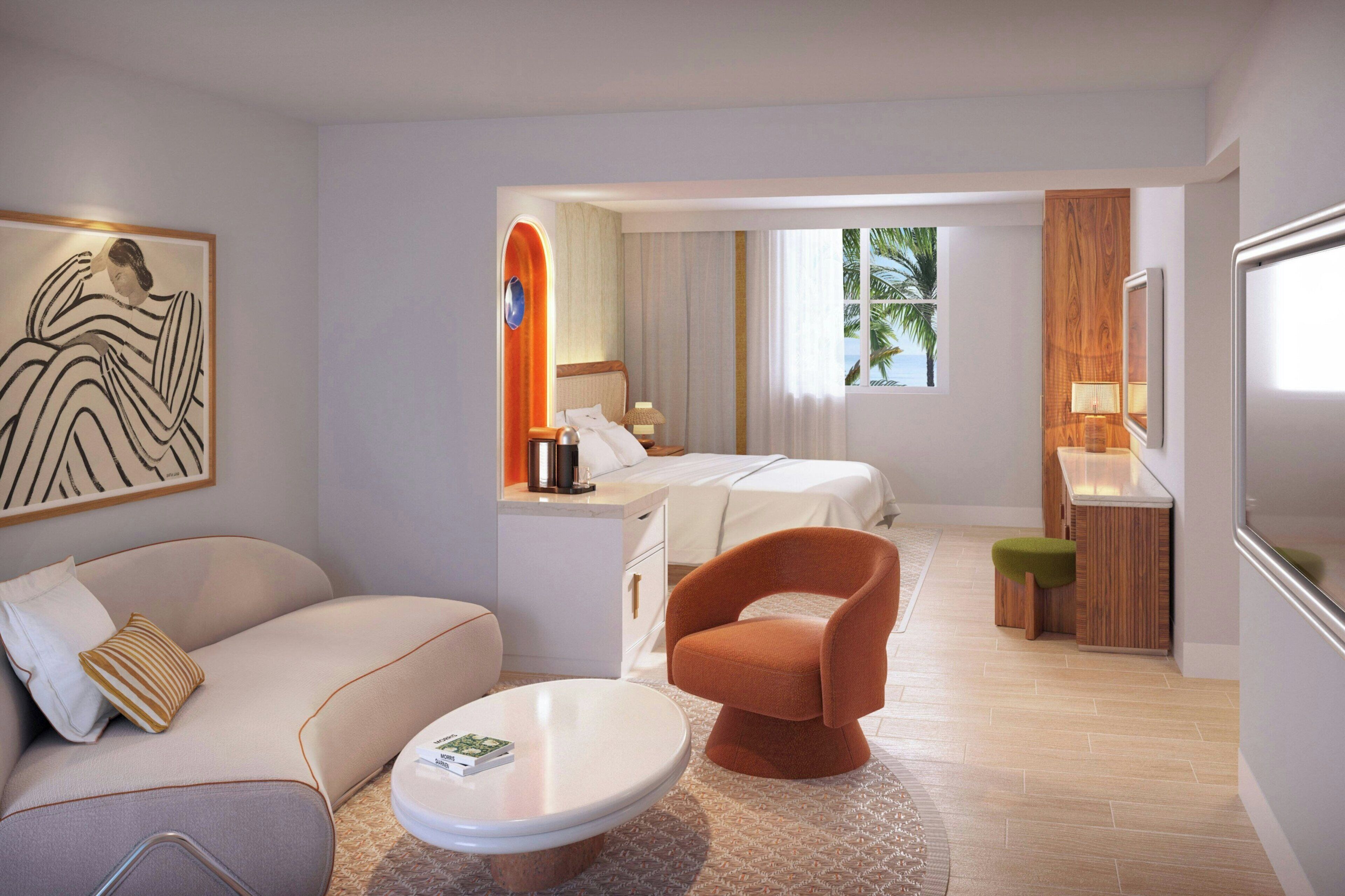 A modern hotel room with a sofa, armchair, dining table, and a bed with a view of palm trees.