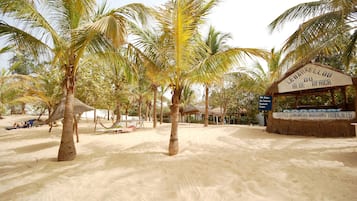 Una playa con palmeras y un letrero que dice "Lebarkellou du Blue Africa".