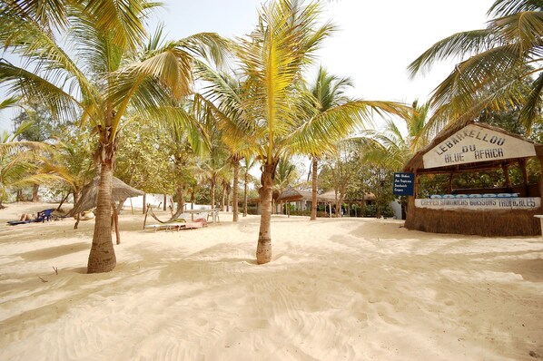 A beach with palm trees and a sign that reads "Lebarkellou du Blue Africa". - Blue Africa (Mbour)