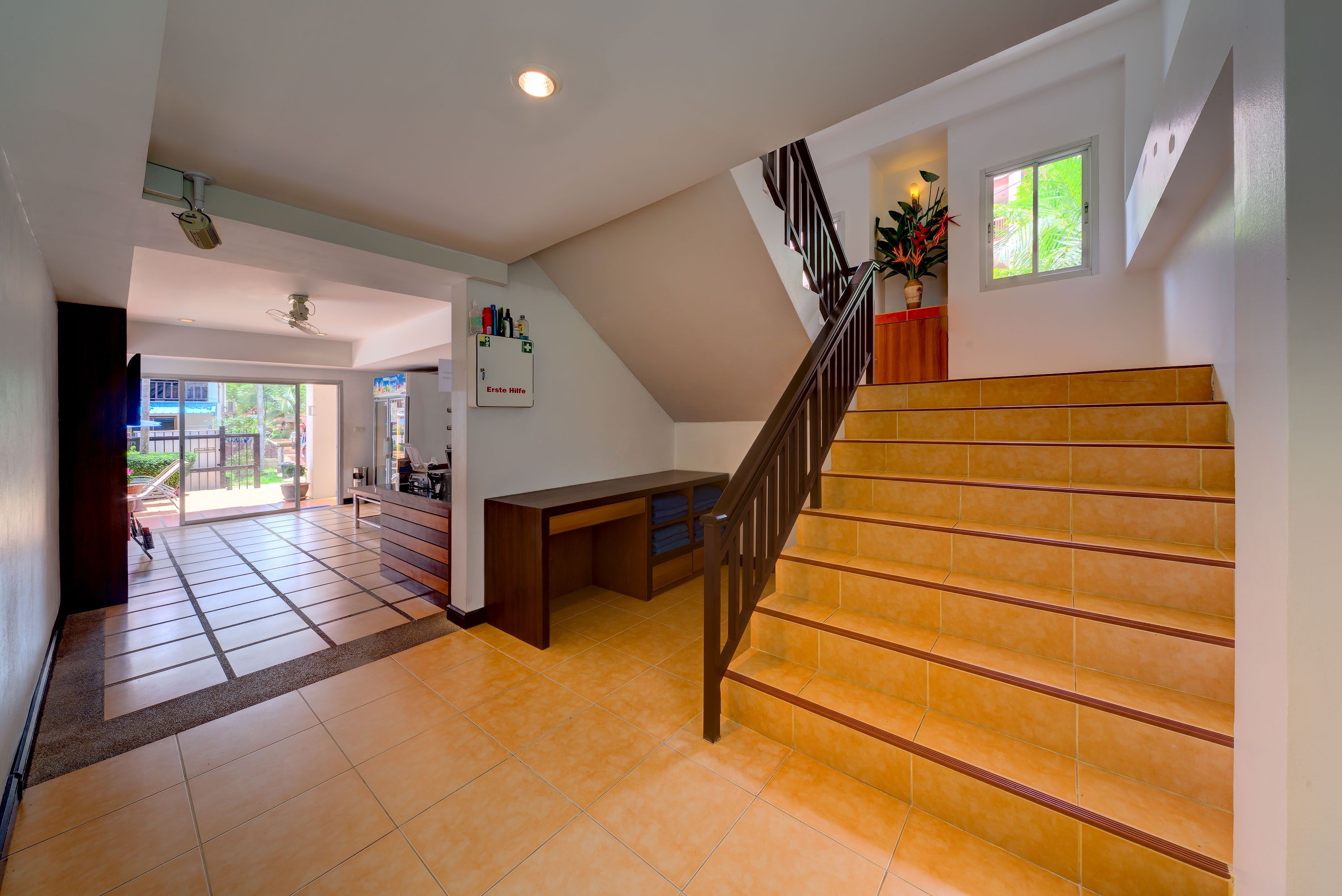 A spacious interior with a staircase, a desk, and a view through a door.