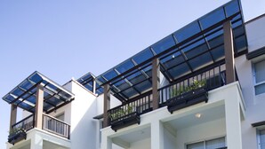 A multi-story hotel with a swimming pool, sun loungers, and outdoor umbrellas. - Krabi Apartment Hotel (Krabi)