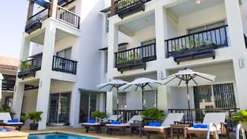 Een buitenzwembad en ligstoelen