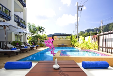 Una piscina al aire libre, sillones reclinables de piscina