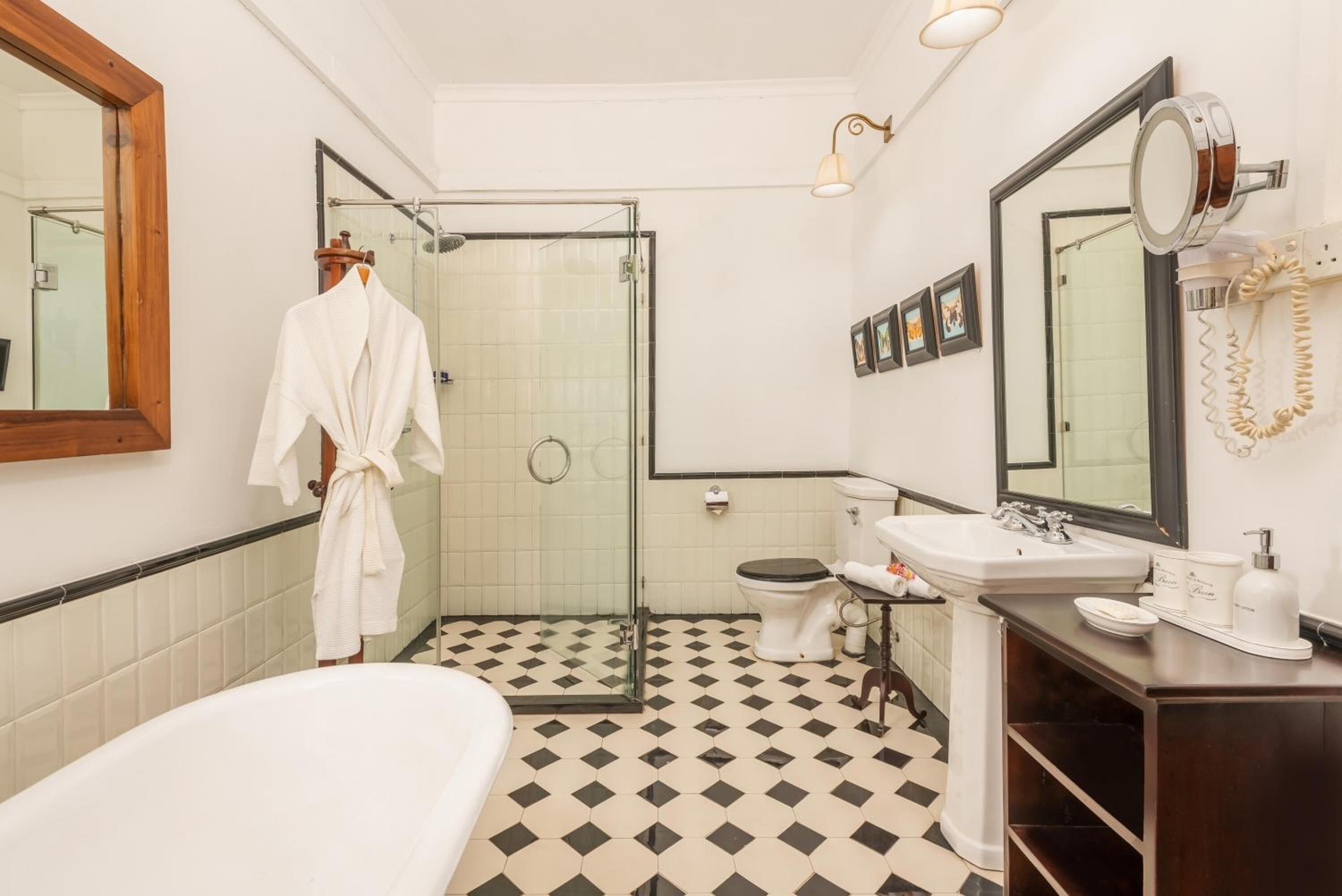 Ein Badezimmer mit Duschkabine, einer weißen Badewanne, einer Toilette und einem Waschbecken mit Spiegel darüber.