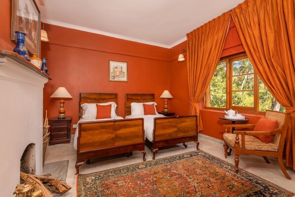 A room with two wooden beds, a large window with curtains, a small table with a teapot, and a chair. - Jetwing Warwick Gardens, A Luxury Reserve (Welimada)