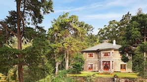 A stone house with a stone facade, a red door, and a well-maintained garden.