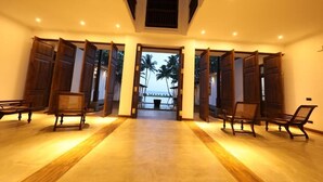 A hallway with wooden doors leading to a balcony with a view of palm trees. - Era Beach (Unawatuna)