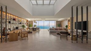 A spacious living area with a large window overlooking the sea, a modern kitchen, and a comfortable seating area. - Rixos The Palm Hotel & Suites – Ultra All Inclusive (Dubai)