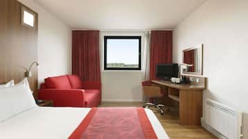 Habitación de hotel con una cama grande, un sillón rojo, un escritorio con computadora y un televisor.