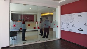 A modern office space with glass partitions, a red accent wall, and a map mural. - Amaris Hotel Ambon (Ambon)