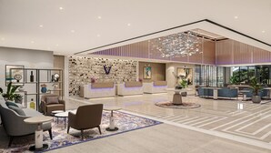 A modern hotel lobby with a reception desk, seating area, and a large chandelier. - Vivanta Thane LBS Road (Thane)