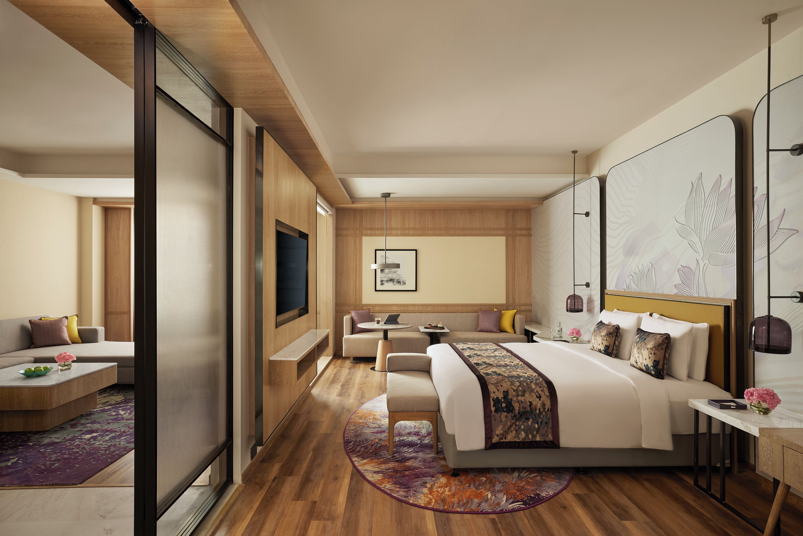 Een moderne hotelkamer met een groot bed, een bank, een bureau en een televisie.