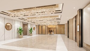 A spacious lobby with a high ceiling, marble flooring, and a large chandelier. There are potted plants and a reception desk in the background. - Vivanta Thane LBS Road (Thane)