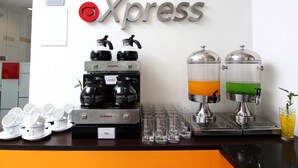 A coffee station with branded dispensers and a sign for 'Xpress' on the wall.
