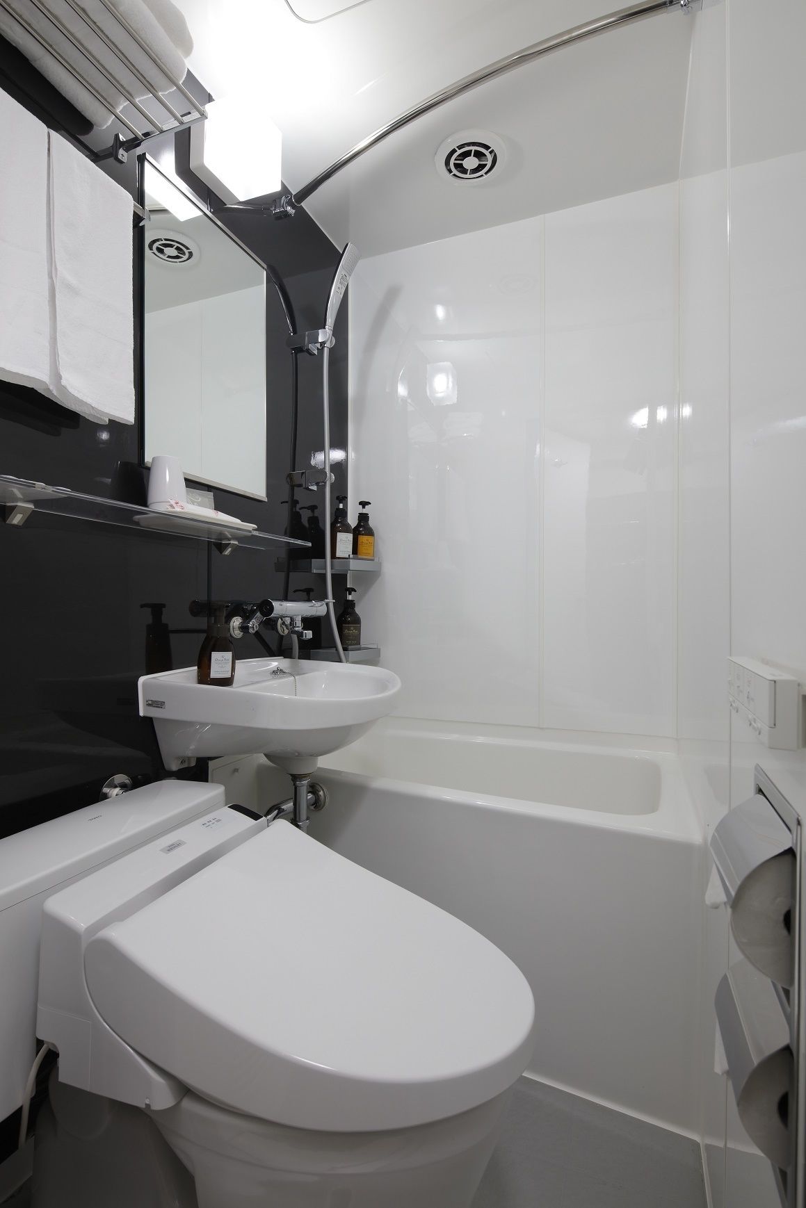 A modern bathroom with a white toilet, a sink, and a bathtub.