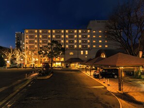 A hotel with multiple floors, a covered entrance, and a parking area. - Senri Hankyu Hotel Osaka (Toyonaka)