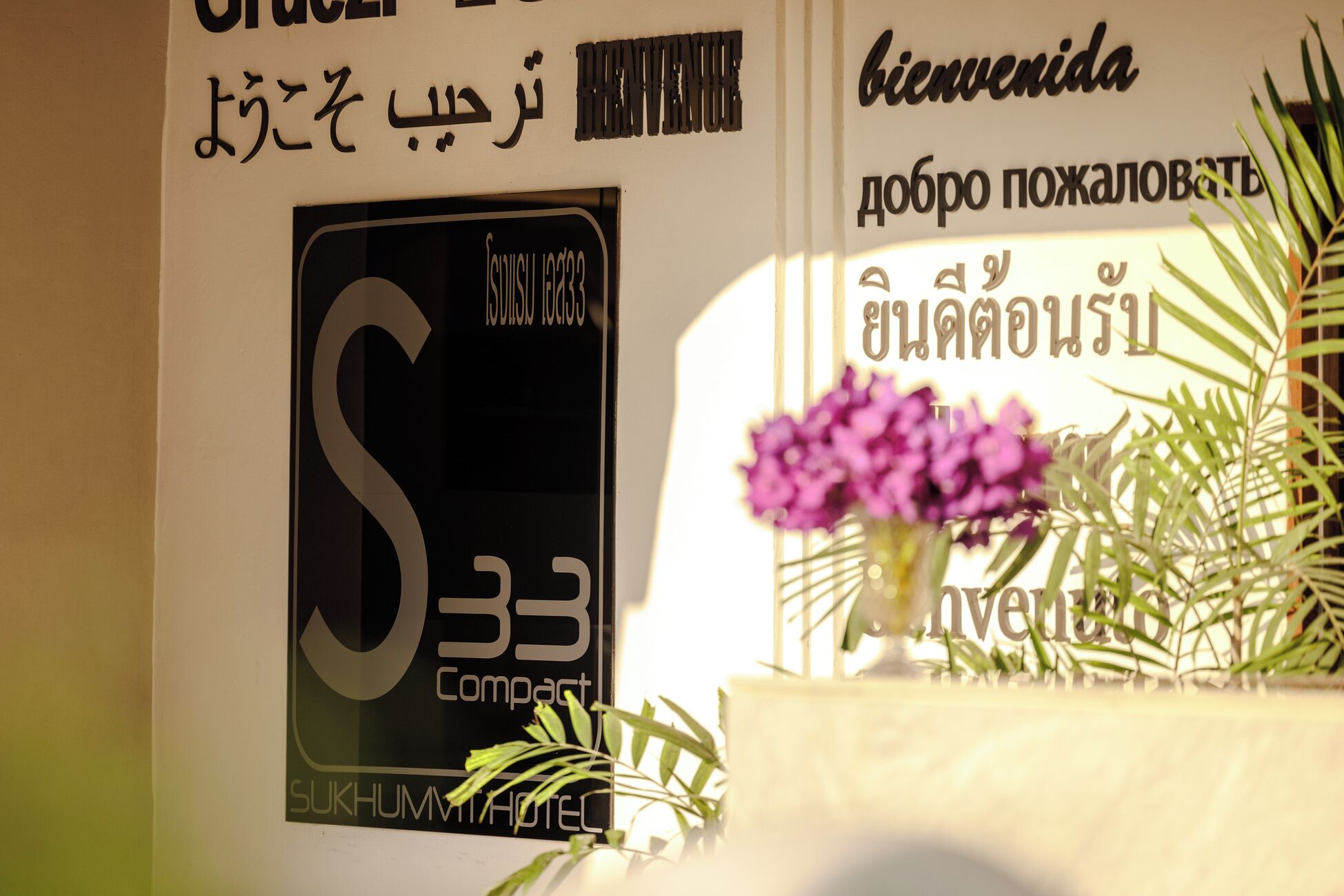 A sign with the number '33' and the word 'Compact' indicating a room number or type.