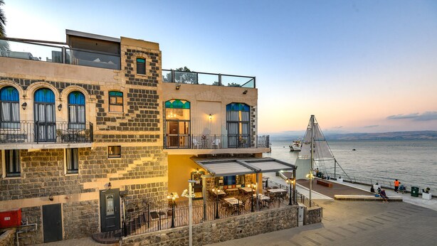 A waterfront building with outdoor seating, a balcony, and a view of the sea. - Shirat Hayam - Boutique Hotel (Tiberias)