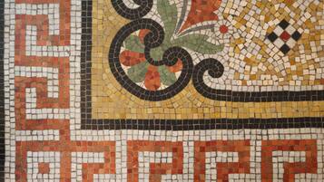 A detailed mosaic tile pattern with geometric shapes and floral designs.