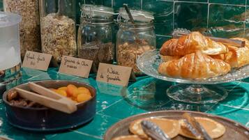 A breakfast buffet with various food items and labels in a kitchen setting.