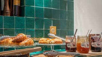 Un bufé de desayuno con croissants, mermeladas y miel a la vista.