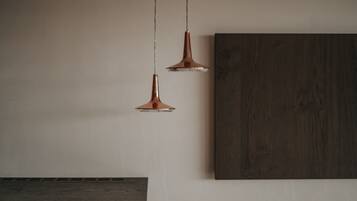 Two pendant lights hanging from the ceiling, a dark wooden cabinet, and a large dark wooden panel on the wall.