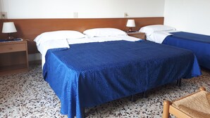 A hotel room with two beds, a wooden headboard, a small wooden nightstand with a lamp, and a chair. - B&B Garnì Da Vito (Jesolo)