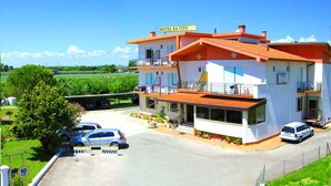 A two-story building with a sign reading "HOTEL DA VITO." There are cars parked in front, and a pedestrian bridge is visible. - B&B Garnì Da Vito (Jesolo)