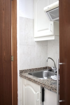 A kitchen with white cabinets, a granite countertop, and a stainless steel sink. - Tropical (Puerto de la Cruz)