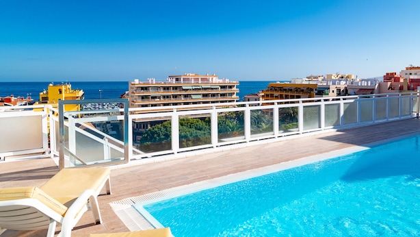 A rooftop pool with a clear view of the ocean and buildings in the background. - Tropical (Puerto de la Cruz)