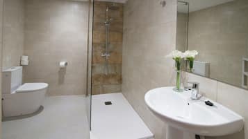 Een bad/douchecombinatie, een haardroger, een bidet, handdoeken