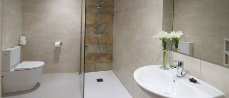 Un baño moderno con ducha, inodoro y lavabo.