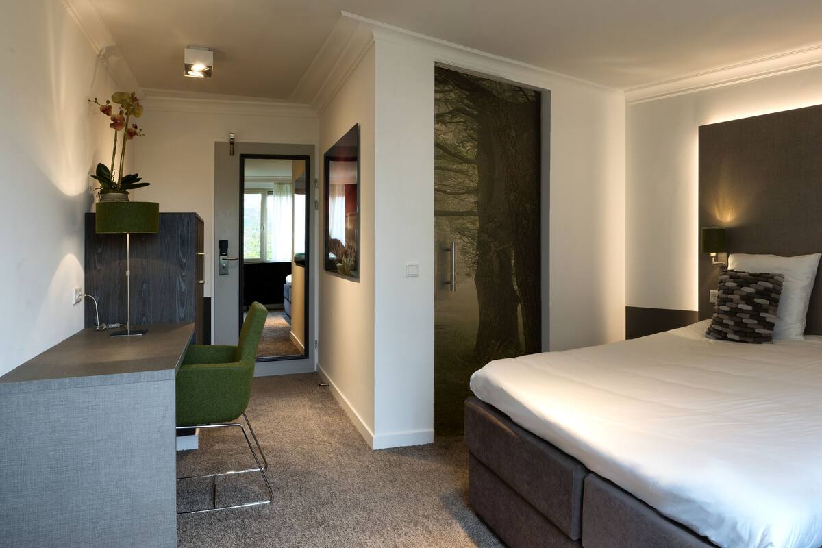 Une chambre moderne avec un grand lit, des tables de chevet, un bureau et une chaise.