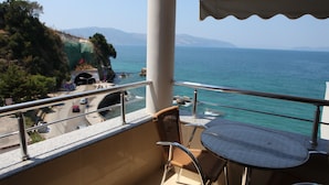 Ein Balkon mit Meerblick, einem Tisch und Stühlen.