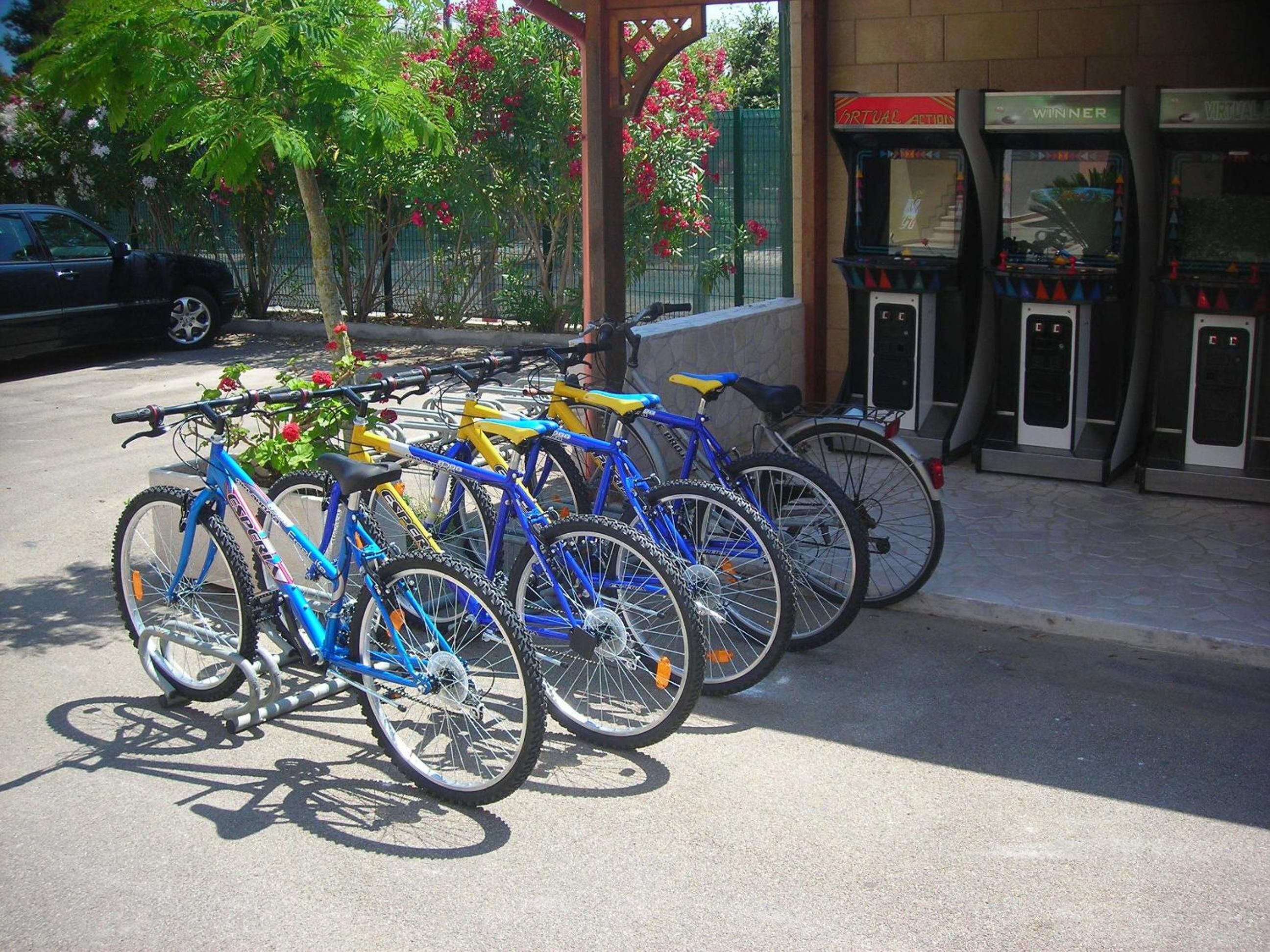 Una fila de bicicletas estacionadas frente a un edificio con máquinas recreativas que dicen "WINNER".