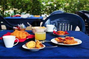 A table set with breakfast items including croissants, toast with jam, waffles, and a glass of orange juice. - Oasi Salento Residence Hotel (Melendugno)