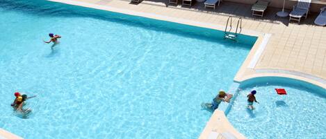 A swimming pool with multiple lanes, sun loungers, and umbrellas.