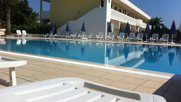 Una piscina al aire libre, sombrillas
