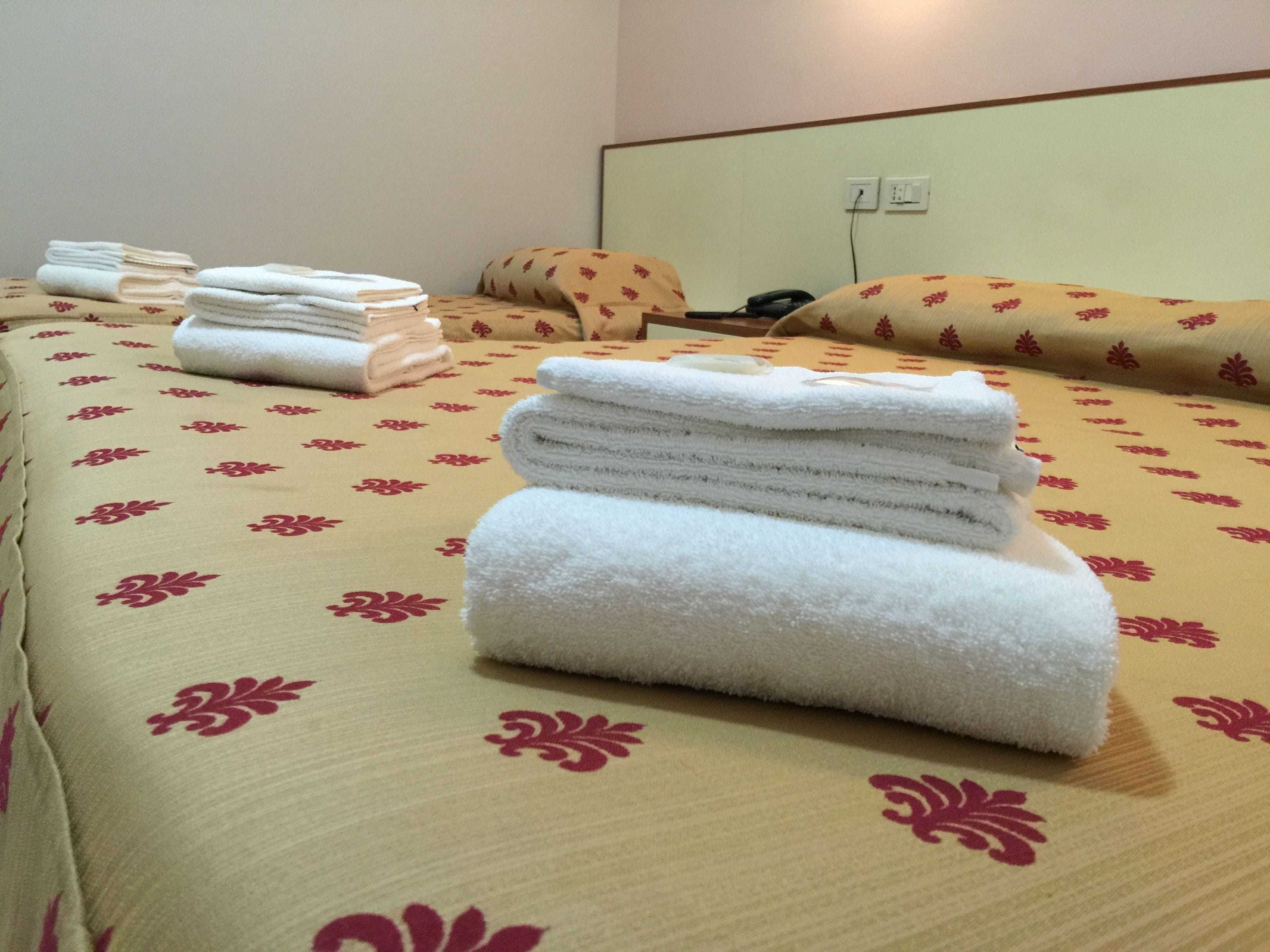Une chambre d’hôtel avec un lit, des oreillers et un téléphone.