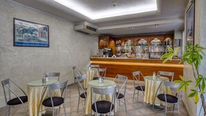 A bar area with a counter, shelves of bottles, and a ceiling with skylights. - Albergo La Posta Arezzo (Civitella in Val di Chiana)