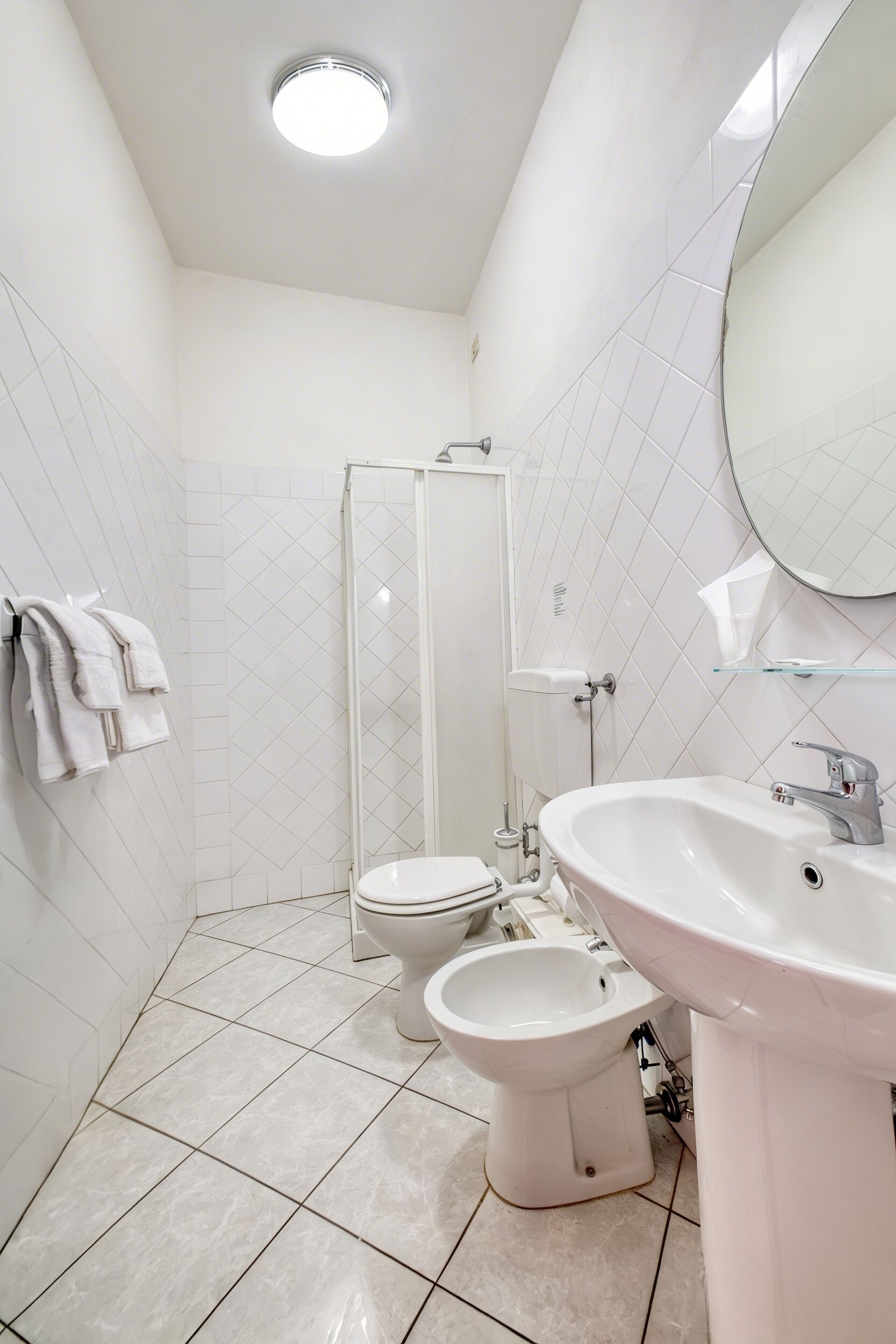 A bathroom with a toilet, bidet, and a sink.