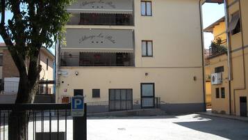 Un immeuble doté de balcons et d’une enseigne sur laquelle on peut lire : « Alberto La Posta ».
