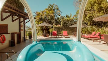 Una piscina al aire libre, sombrillas, tumbonas